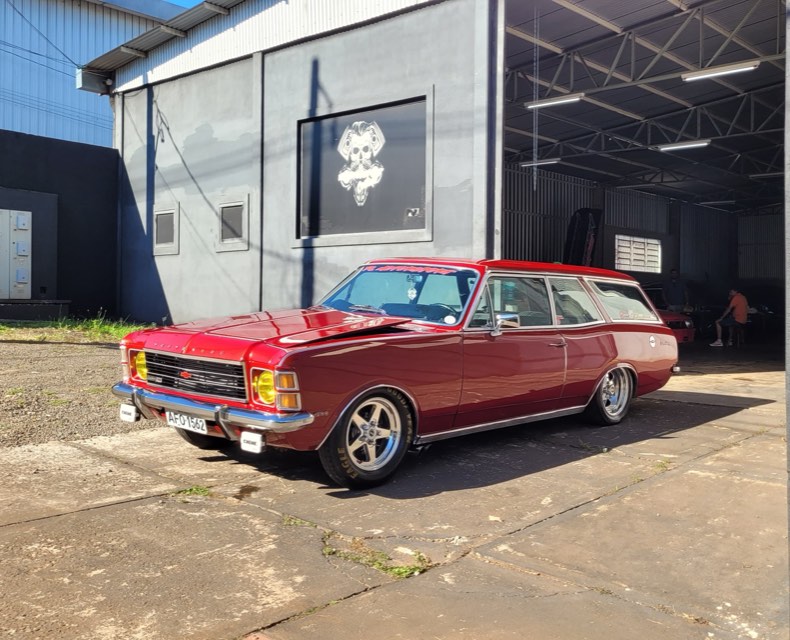 Caravan vermelha estacionada em frente à oficina FL Motorsport