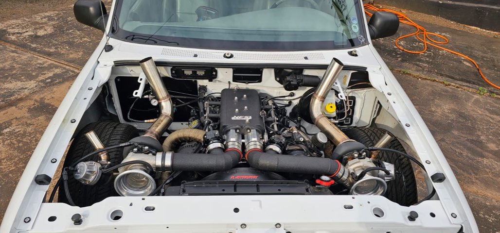 Cofre de carro branco com motor biturbo preparado pela FL Motorsport, com dois turbos e coletores em inox