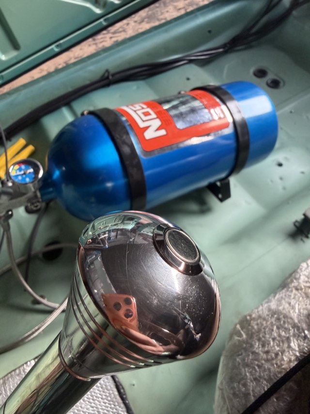 Cilindro de nitro NOS e manopla de câmbio cromada no interior do carro
